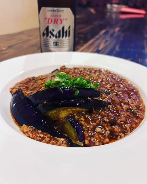 茄子とひき肉の料理、ビールの写真